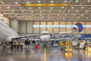 Aircraft inside FL Technics maintenance hangar, with engineers and equipment working on multiple planes